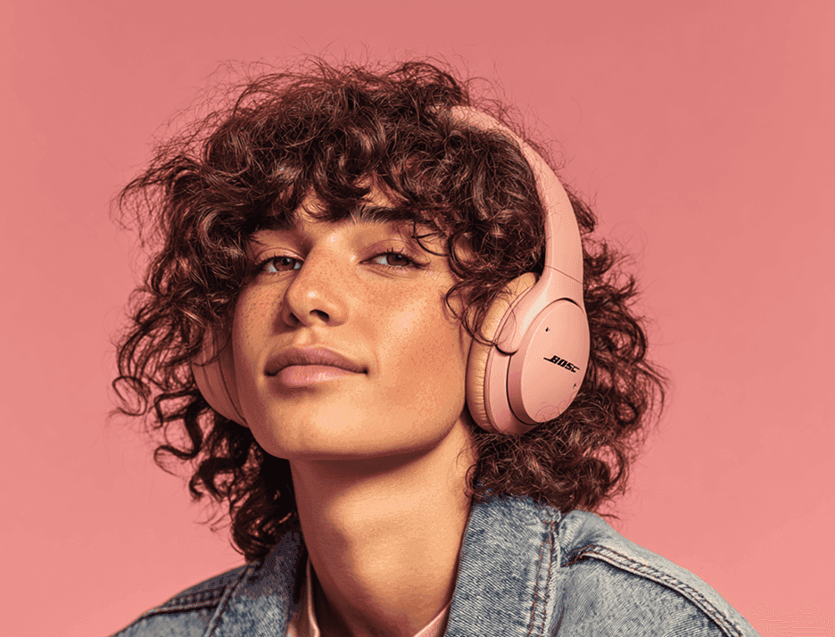A young person listening to music with headphones on, looking at the camera