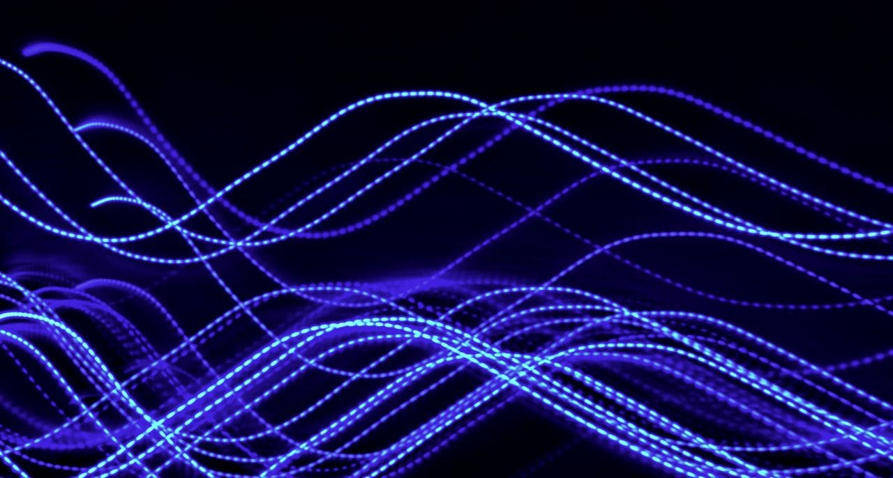 Long-exposure blue light trails weaving across a dark background