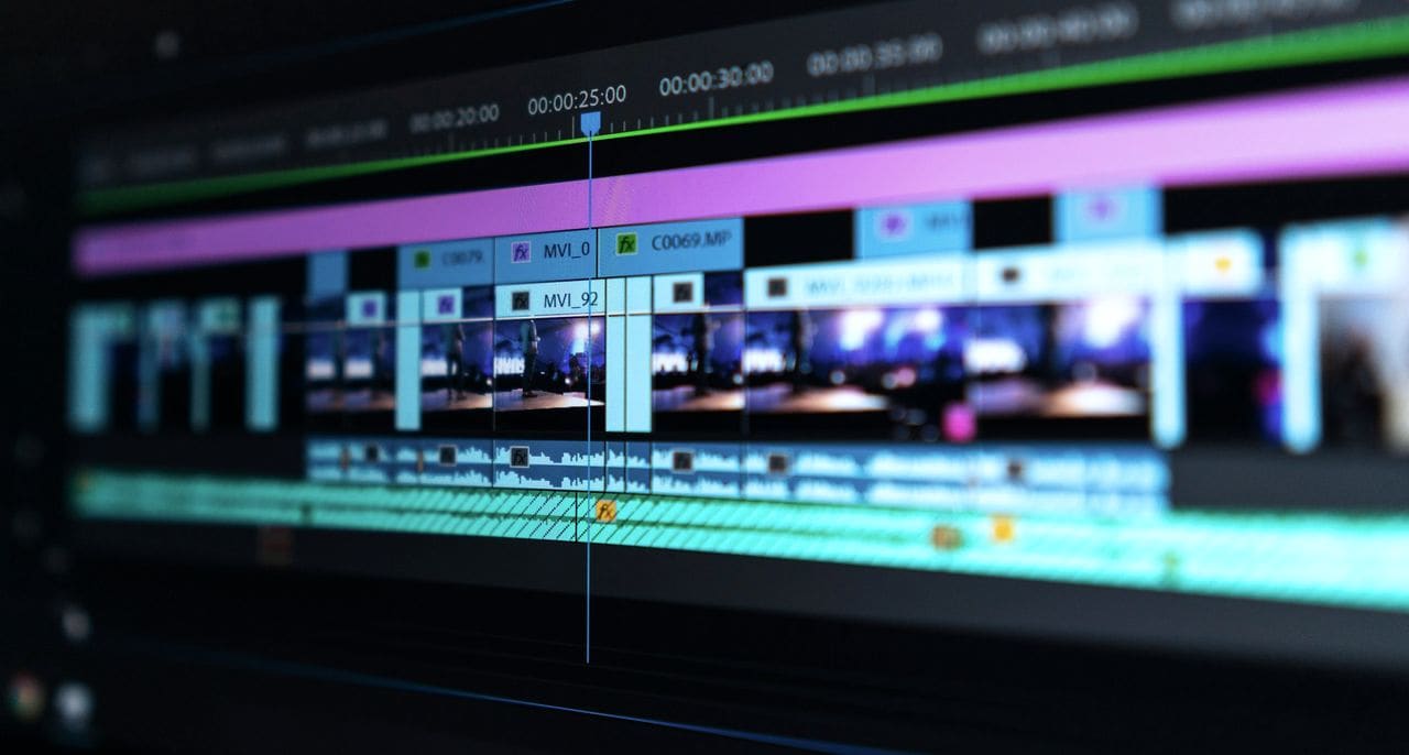 A video editing timeline with blue and purple clips on a dark screen